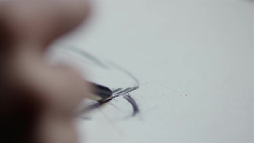 An artist draws lines on paper then erases
