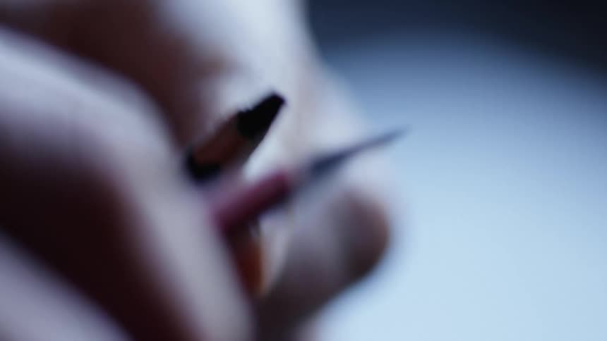 Person sharpens pencil with an stylus blade