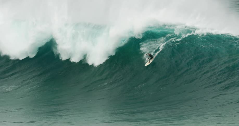 A surfer rides a huge wave