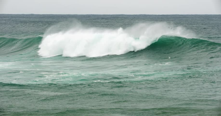 A crashing wave in the ocean on a cloudy day