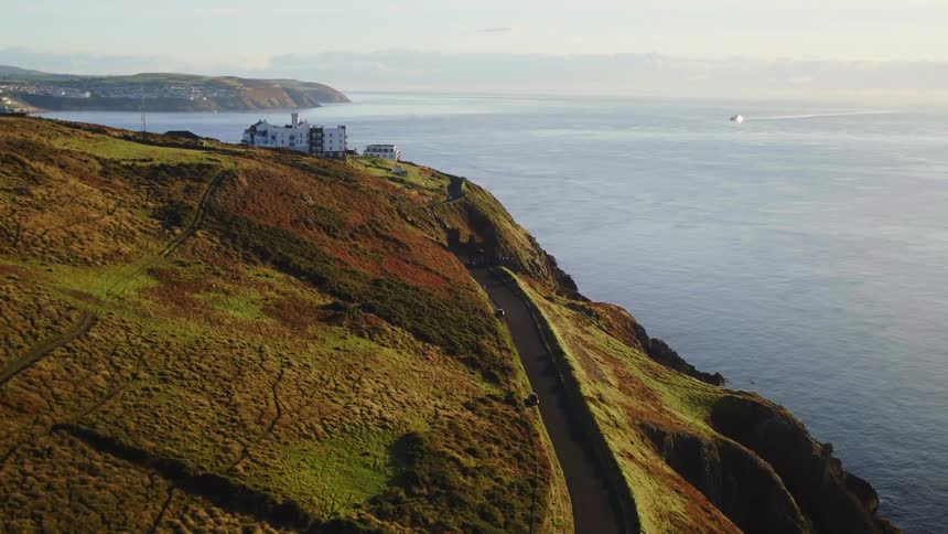 Rural highway along coastal cliffs above ocean leads to hotel