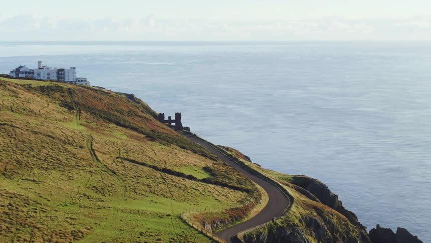 Aerial view of an oceanside cliff with a winding road