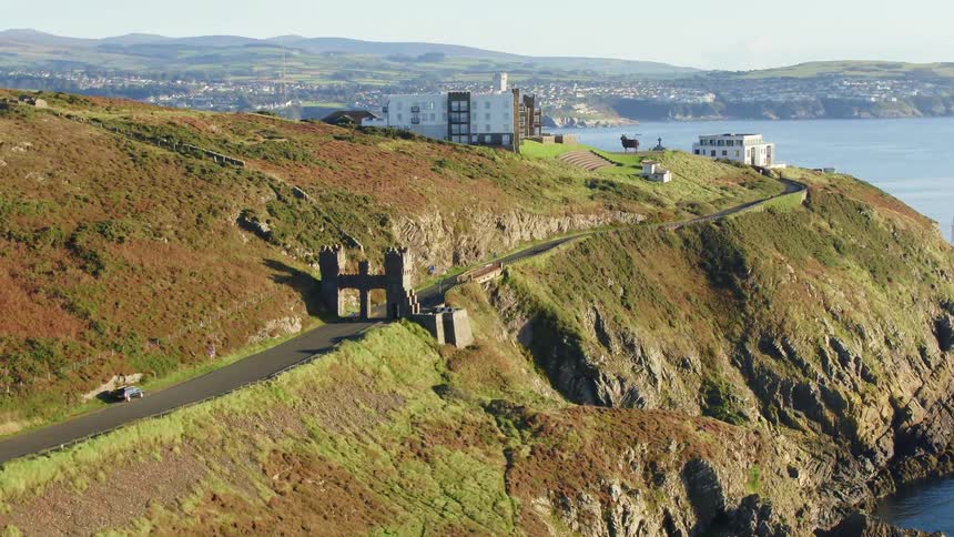 The top of the hill by the shore has far apart homes