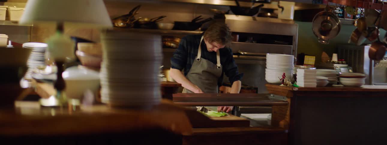 Man chops vegetables in commercial kitchen