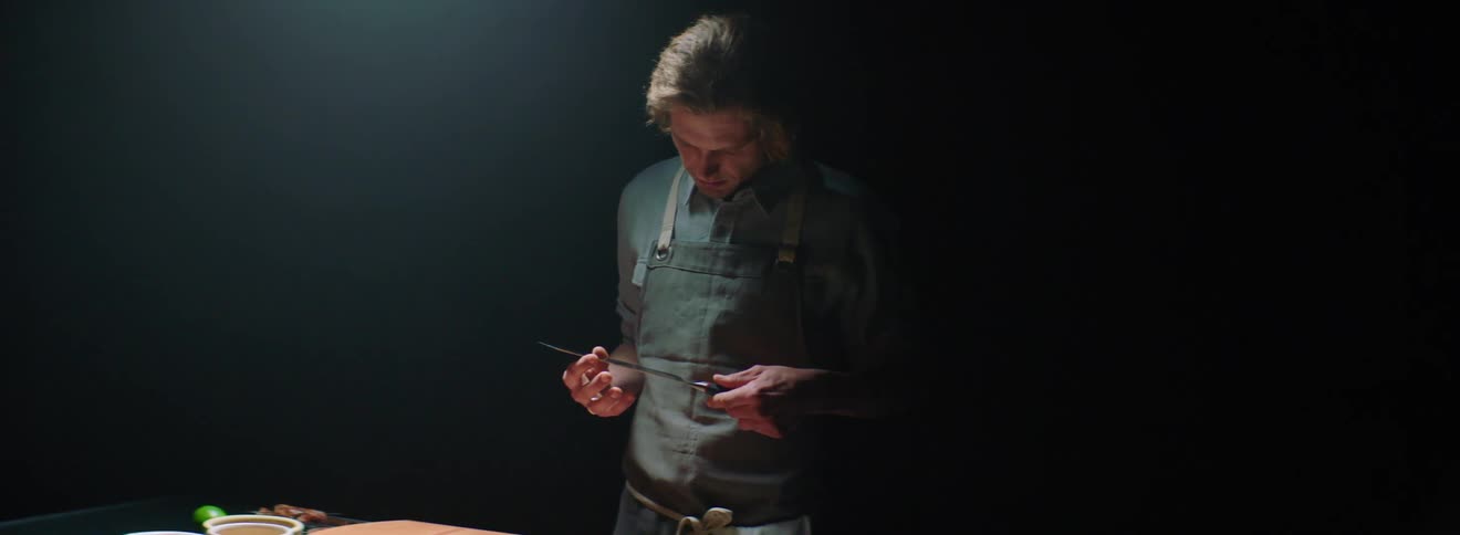 Man contemplates knife near kitchen counter