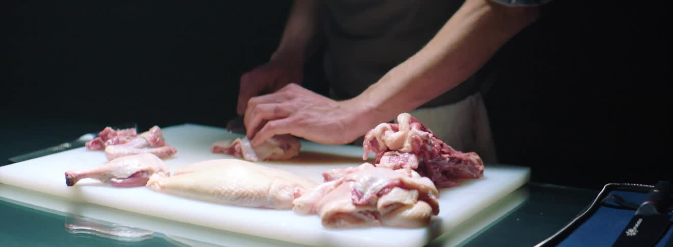 A man cuts meat on a cutting board