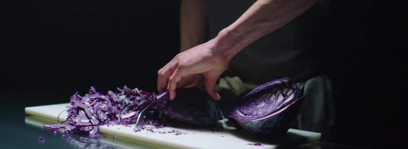 Man chops purple cabbage