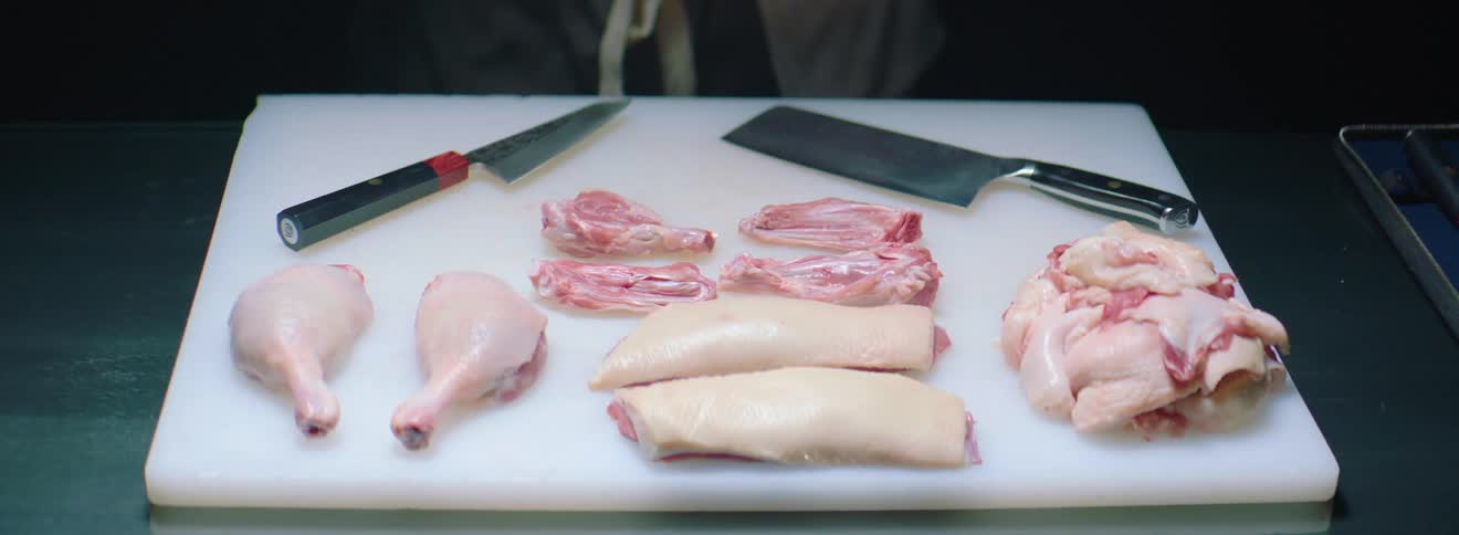 Different meats are cut up on the cutting board