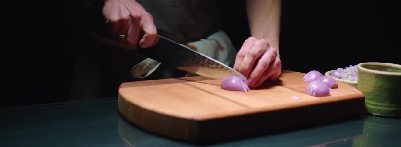 A man slices shallots