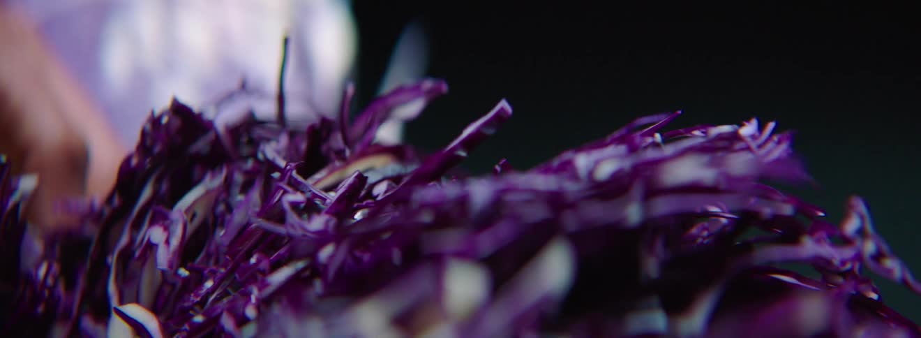A person chops purple cabbage