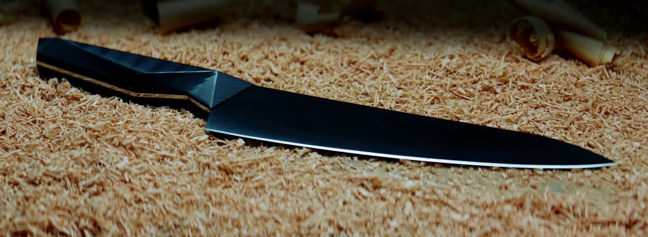 A sharp chefs knife on a pile of sawdust