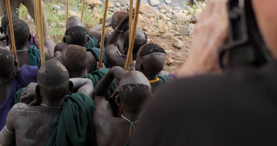 A photographer captures a tribe as they sit and pose for the camera