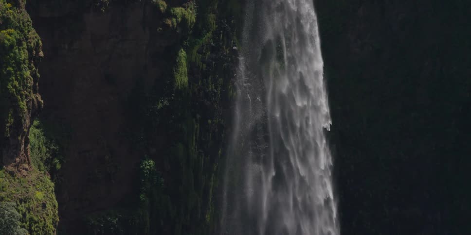 Aerial view of a waterfall dropping from a tall cliff