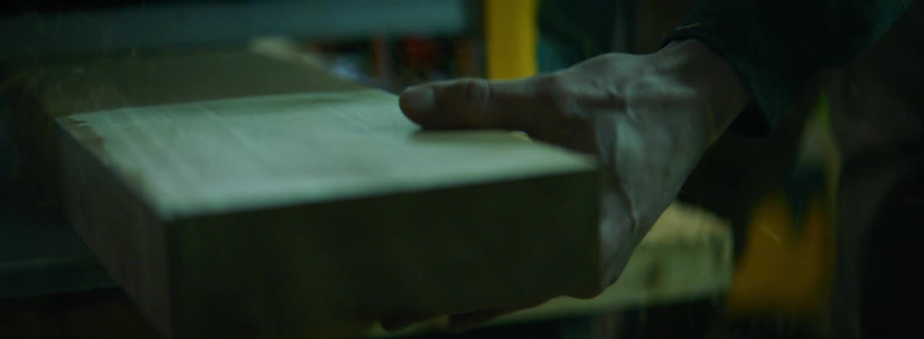 A woodworker using a planer on a piece of wood