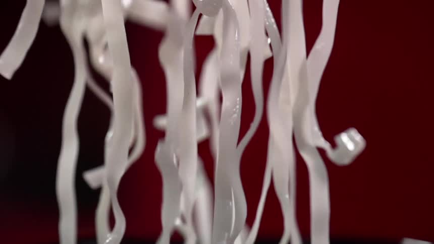 White rice noodles are dropped into a wok