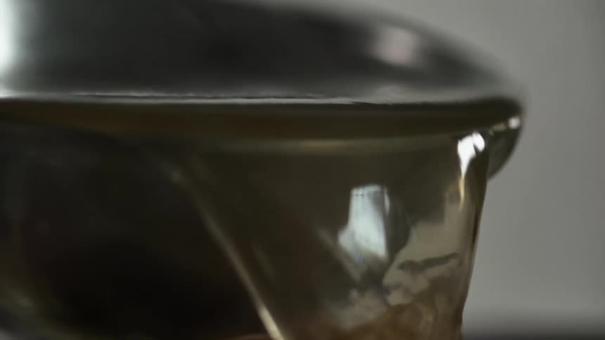 Hot broth is poured out of a ladle or bowl