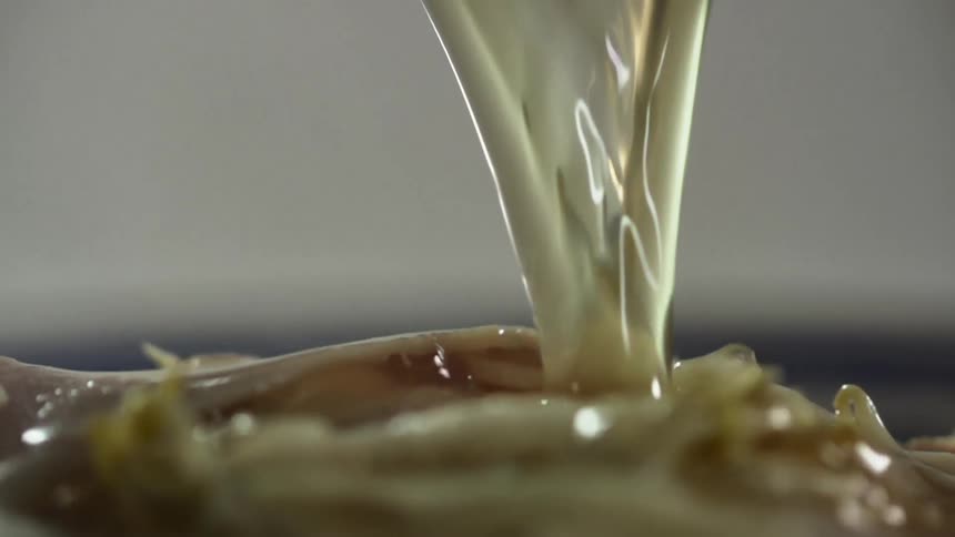 Fluid pours over food from a container