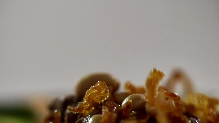 Crumbs fall over the filling of a green flour tortilla wrap