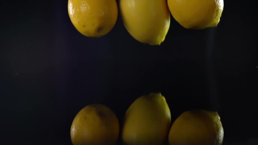 Three lemons falling on to a counter
