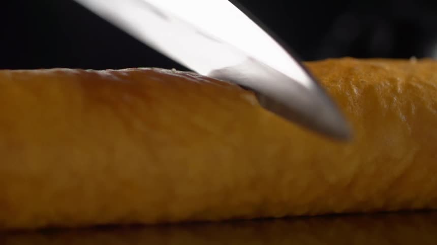A knife cutting through a loaf of bread
