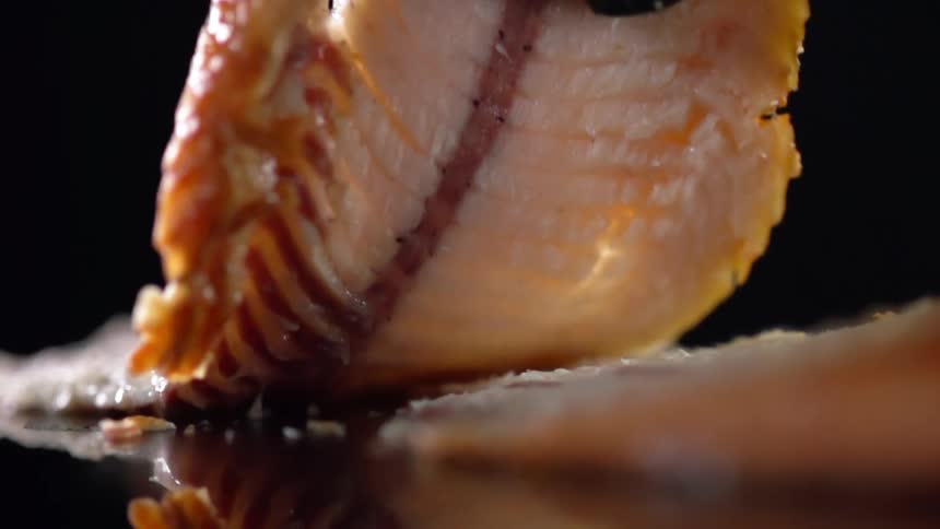 A person picks up a piece of fish