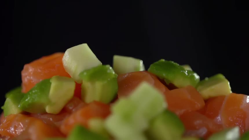 Small avocado pieces mixed with pieces of salmon
