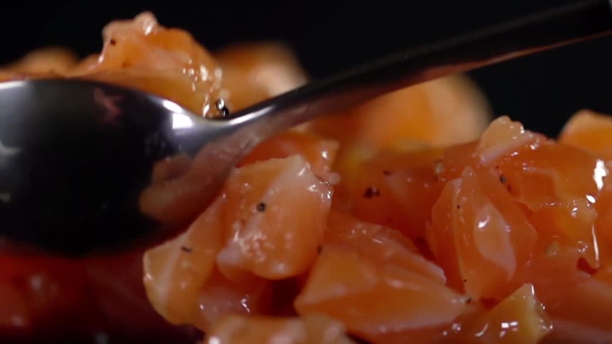 Metal spoon stirring finely chopped salmon