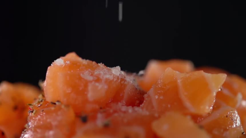 Salt is added to salmon cubes