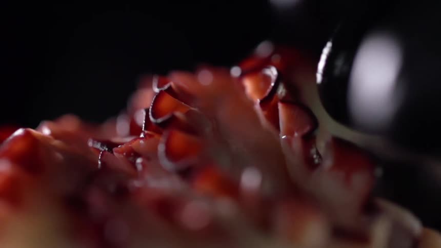 A person lays strips of a sliced octopus tentacle atop one another