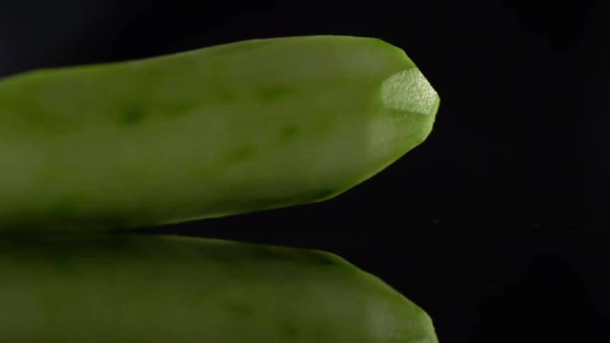 A peeled cucumber falling on a counter