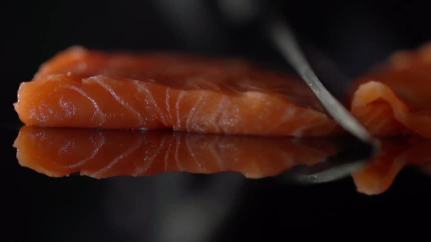 A person cuts a piece of salmon