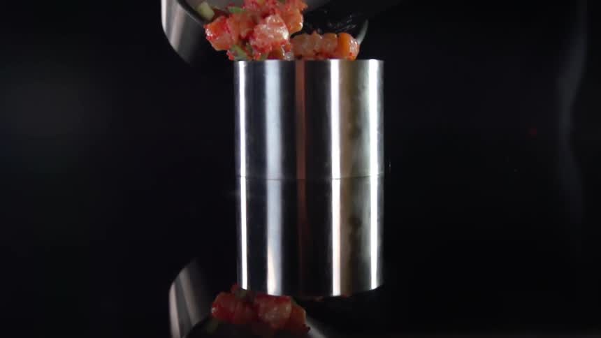 A bowl of food is poured into a metal container