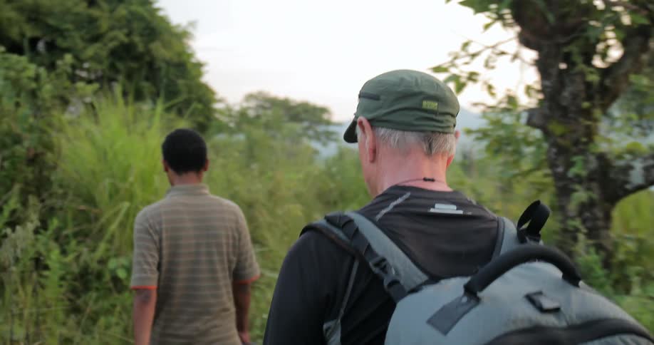 Two men are hiking outside on a cloudy day