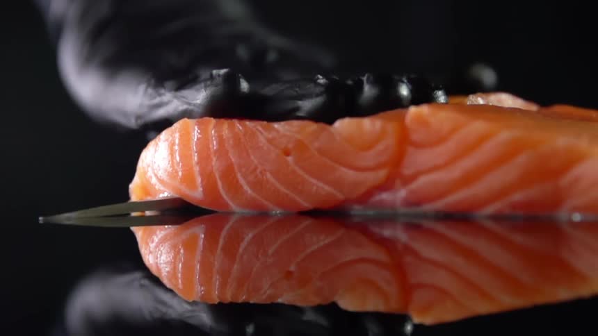A person slicing a salmon filet