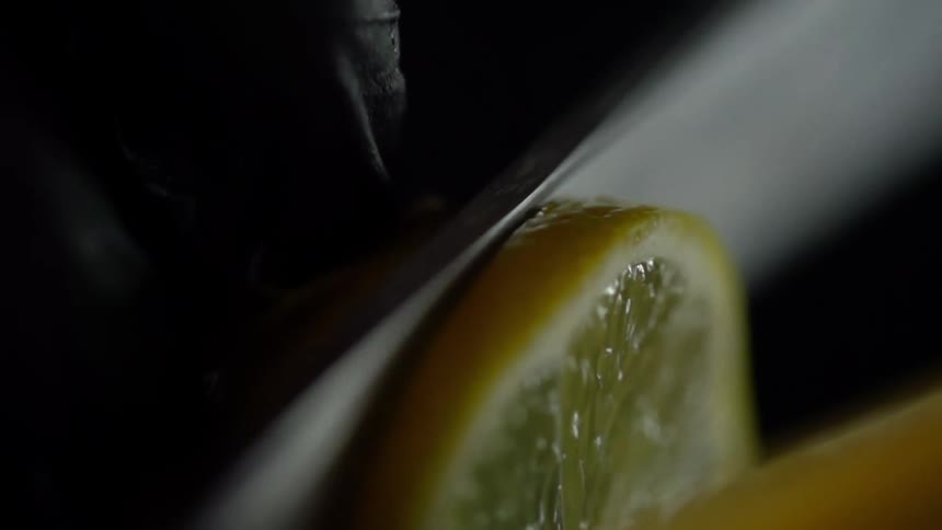 A lemon being sliced with a knife