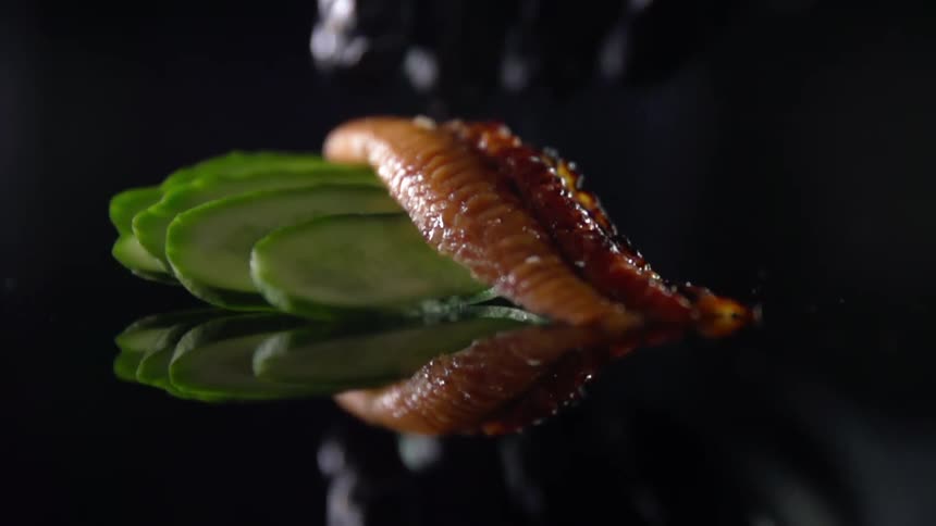 Slice of fish being laid on top of sliced vegetables