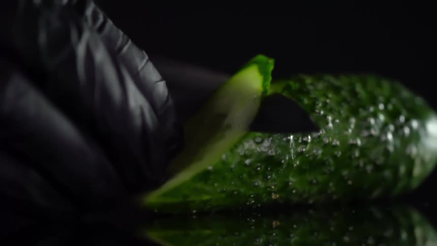 A person cutting a cucumber
