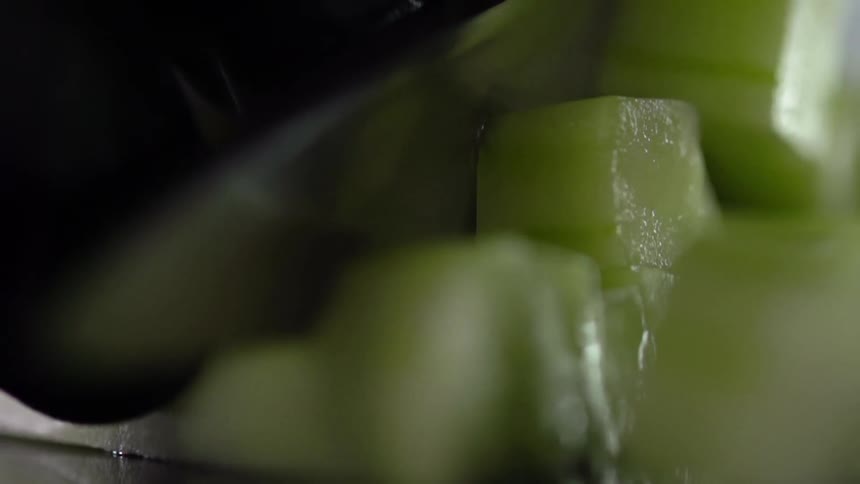 Blade cuts sliced produce into cubes