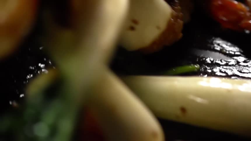 Shrimps and vegetables cooking in a hot cast iron pan
