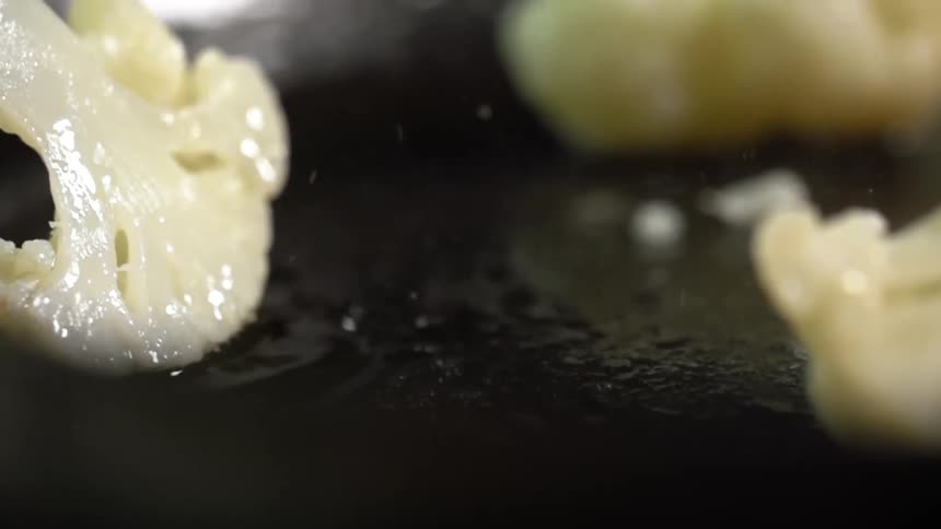 Cauliflower frying in a pan of oil
