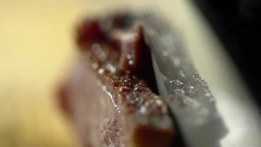 Man cuts a cooked juicy steak with a knife