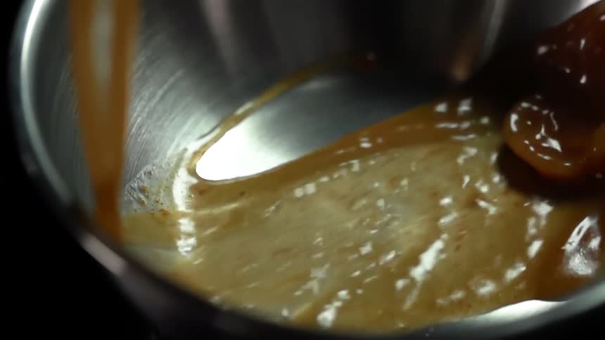 Brown broth is poured into a saucepan