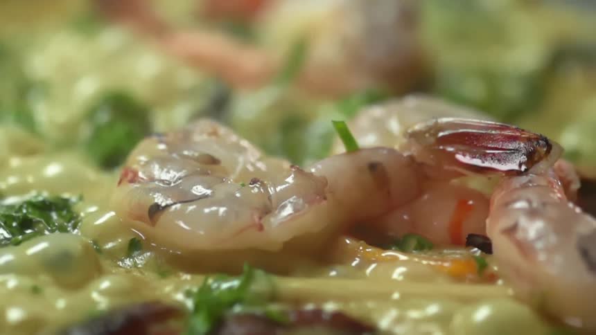 Shrimp frying in curry surrounded by vegetables