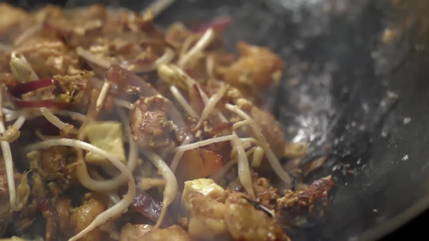 Tofu is added to vegetables cooked in the wok