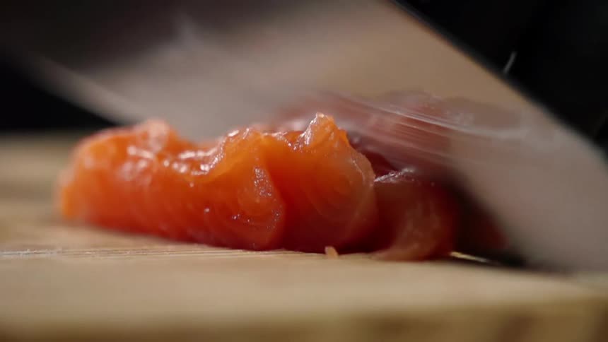 Blade reflects salmon being sliced