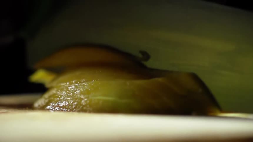 Mango being sliced with a sharp knife