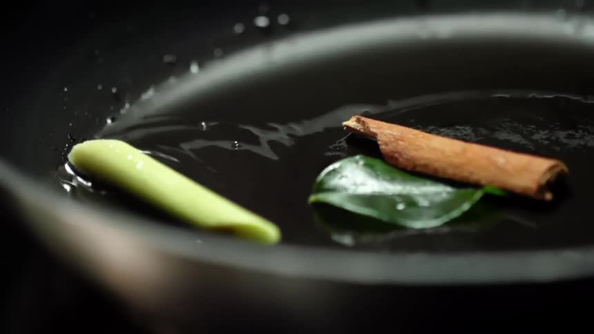 Сinnamon stick falls onto a pan coated with oil
