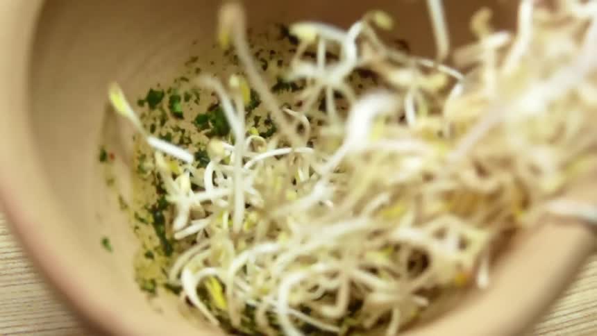 Bean sprouts are dropped into a mortar bowl