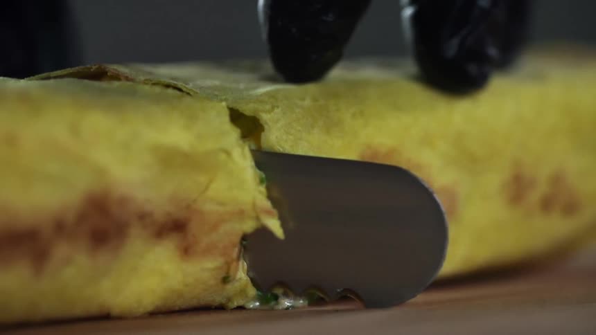 A person cuts a wrap in half