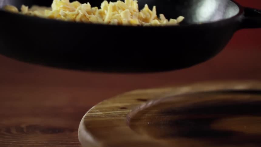 A person lifts up a frying pan with food in it